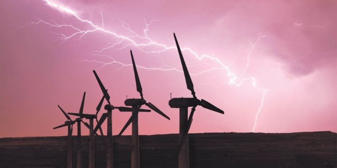 Several wind turbines under the lightning weather.